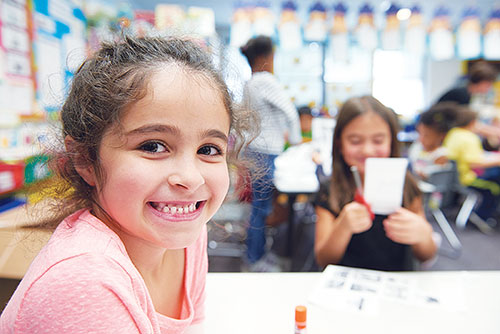 Graphic of a child smiling in a classroom