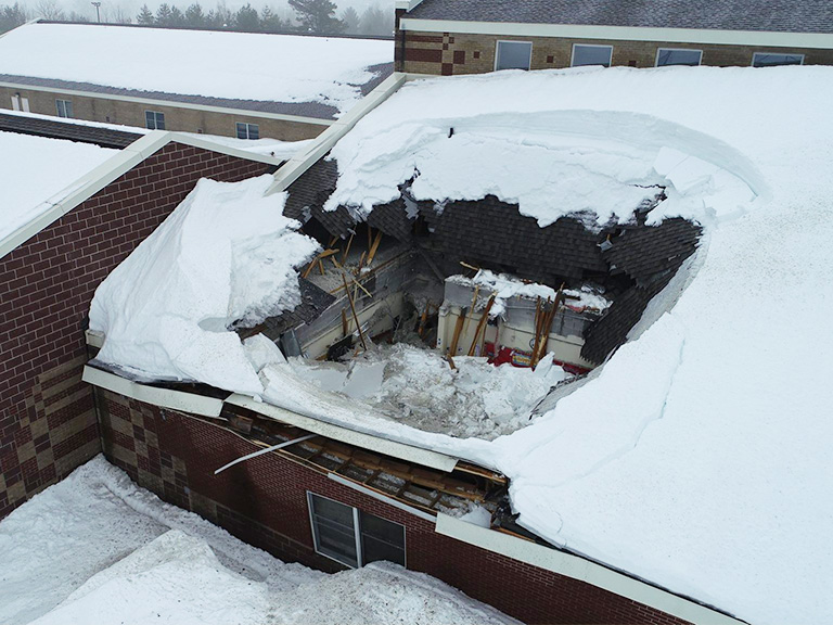 image of a hole in a school roof due to heavy snow and ice